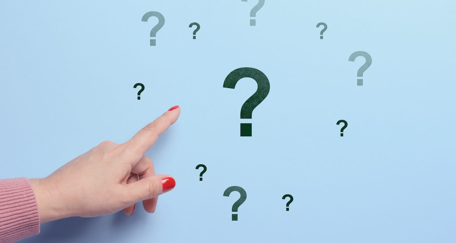 Woman's hand pointing to a question mark on a blue background. Search for an answer, find the truth